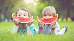 Kids eating watermelon on grass
